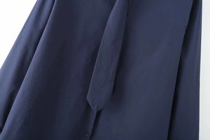 Detail of dark blue poplin shirt featuring button-down front and matching necktie design