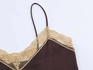 Detail of dark brown satin top featuring delicate beige lace trim along the neckline