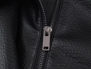 Detail of premium lychee texture leather jacket with smooth silver metal zipper system