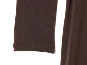 Detail view of dark brown knitted dress showing tight ribbed texture and cuff stitching