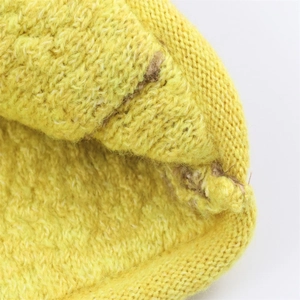 Detailed close-up of yellow knit fabric texture with fine stitching and soft wool material