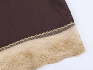 Macro detail of dark brown satin fabric with beige lace trim and floral embroidery