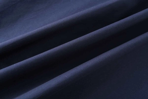 Macro detail of navy blue cotton poplin fabric texture showing smooth plain weave pattern
