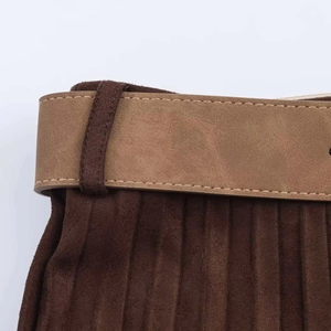 Detailed close-up of dark brown pleated fabric with a light brown leather waist belt
