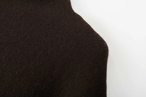 Nahaufnahme der dunkelbraunen Wollstofftextur und der asymmetrischen Schnittkanten