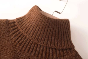 Detail shot of a ribbed knit high neck sweater collar in dark brown wool texture fabric