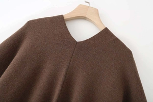 Close-up of V-neck collar and knit texture on a dark brown loose oversized poncho