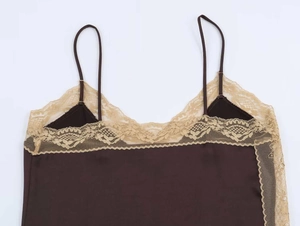 Detail of dark brown satin camisole featuring delicate beige lace trim and thin straps