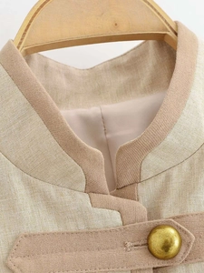 Detail of light khaki linen jacket featuring a refined mandarin collar and golden button
