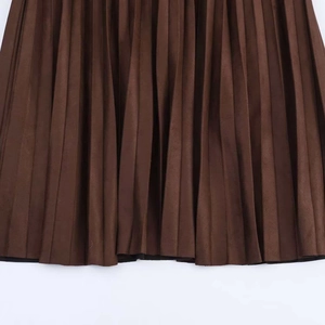 Detailed close-up of brown pleated skirt fabric showing dense texture and accordion folds