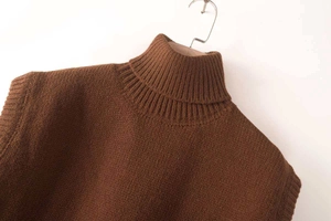 Detail shot of a dark brown ribbed knit turtleneck vest with high-quality texture