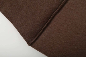 Macro view showing the fine stitching and thick brushed texture of dark brown V-neck poncho coat