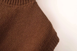 Detailed macro view of the dark brown ribbed knit collar on the sleeveless vest