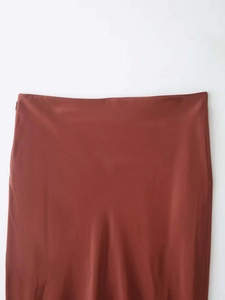 Detail of rust red satin skirt showing smooth waistband and invisible side zipper
