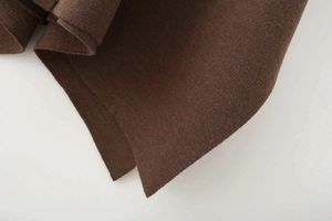 Detailed macro view showing the textured dark brown wool blend fabric and loose cape edge