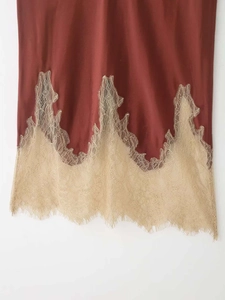 Detail of red brown satin skirt with contrast beige eyelash lace hem and silky fabric