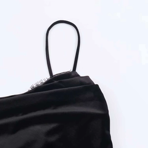 Gros plan d'une robe en velours noir avec bordure en dentelle et fines bretelles