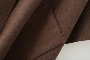 Detailed macro view of dark brown knit fabric texture with precision stitching and soft nap