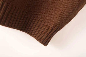 Detailed macro view showing the high-quality ribbed hem of the brown knit sweater vest