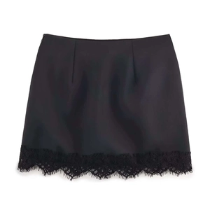Detailed view of the black mini skirt featuring delicate eyelash lace trim at the hem