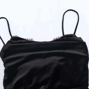 Détail de robe en velours avec dentelle délicate et fines bretelles en noir