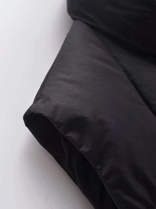 Detail of sleeve stitching and quilted texture on a black puffer vest for women