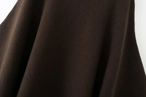Nahaufnahme der dunkelbraunen Strickstruktur dieses asymmetrischen Damen-Ponchos