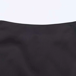 Detail shot of black crepe fabric texture with fine vertical lines and soft ruffle hem