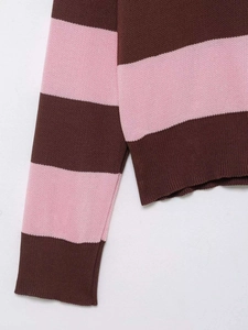 Gros plan d'un pull en maille rayé rose et marron montrant le poignet et la texture