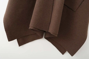 Detailed close-up showing fabric texture and pocket stitching of dark brown wool coat