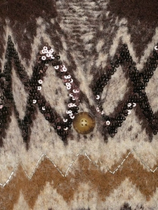Detailed close-up of sequined knit cardigan with jacquard patterns and resin button
