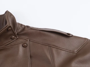 Detailed macro view of vintage brown leather jacket collar with epaulettes and buttons