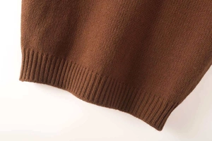 Detailed macro shot of the ribbed hem on a brown knitted vest with fine texture