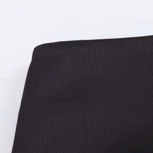 Detailed close-up of black textured fabric with vertical wavy pattern for mini skirt hem