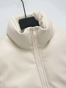 Detailed close-up of cream PU leather vest collar and minimalist metal zipper
