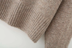Detailed macro view of high-quality oatmeal knit fabric with fine ribbed cuff texture