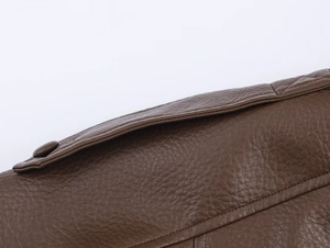 Detail of brown leather jacket shoulder strap with lychee texture and stitching