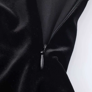 Détail de la fermeture éclair invisible sur une robe en velours noir montrant la texture