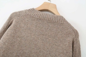 Close-up of the textured rib knit collar and shoulder detail of this brown sweater