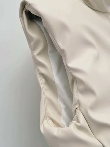 Detailed close-up of cream PU leather vest showing high-quality stitching and soft lining