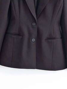 Close-up of black tailored blazer featuring classic notch lapels and two-button closure