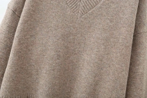 Close-up of brown V-neck sweater showing soft blended wool texture and ribbed collar