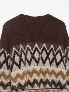 Detail of jacquard knit cardigan featuring geometric patterns and subtle black sequins