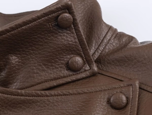 Detailed macro view of litchi texture brown leather jacket with covered buttons