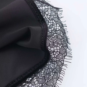 Détail en gros plan de la dentelle cil noire sur une robe nuisette en velours