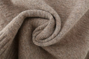 Close-up of soft camel wool knit fabric showing fine texture and warm material detail