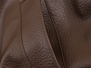 Close-up of dark brown lychee grain leather jacket with detailed stitching work