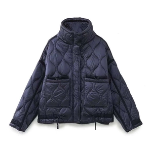 Détail d'une veste matelassée bleu marine avec col montant et grandes poches plaquées
