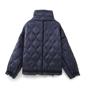 Détail d'une veste matelassée bleu marine avec surpiqûres oignons et finitions noires