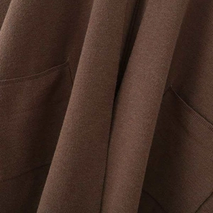 Minimalist deep brown V-neck cape coat featuring soft knit texture and side pockets